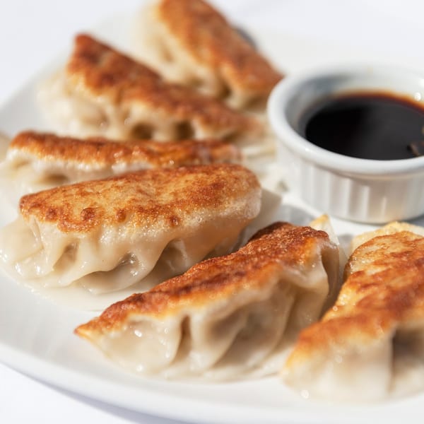 ZEN Kitchen & Bar's pan-fried gyoza with crispy bottoms and a side of soy dipping sauce.